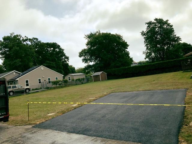 A asphalt driveway is being built in a residential area