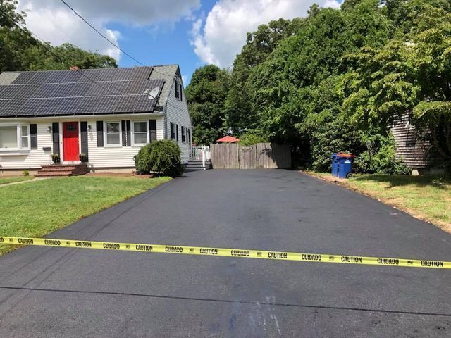 A driveway leading to a house with solar panels on the roof
