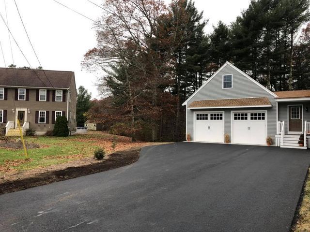 A house with a garage and a driveway in front of it
