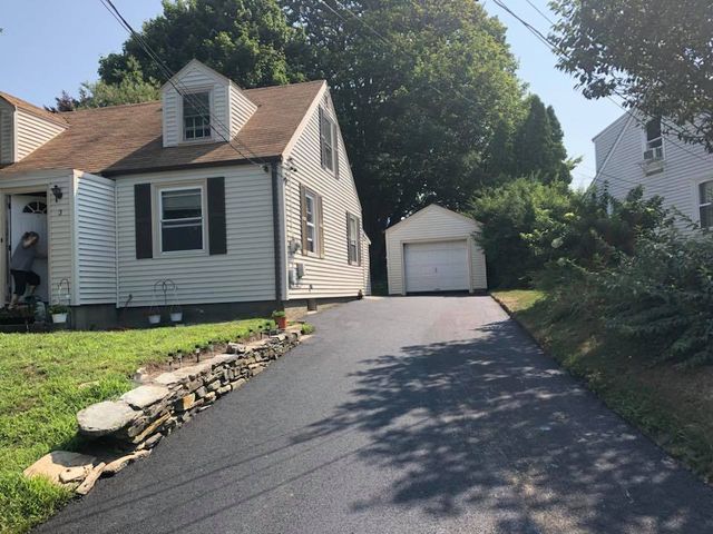 A driveway leading to a house with a garage