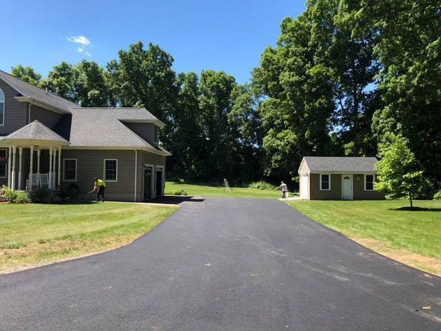 A driveway leading to a house and a shed