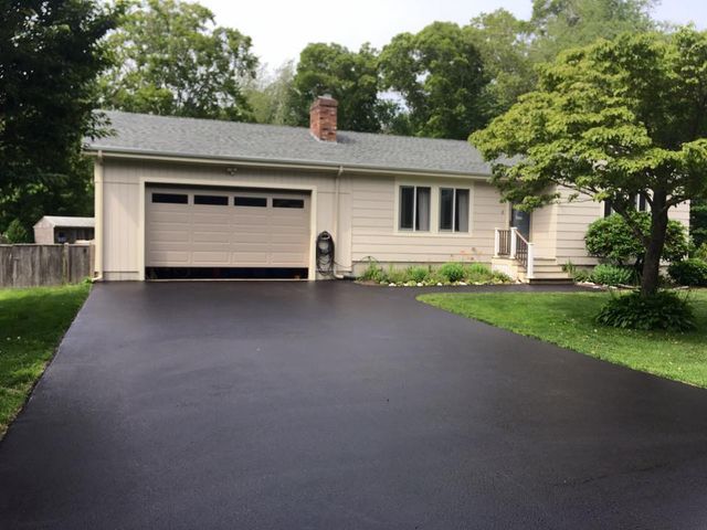 A house with a garage and a black driveway