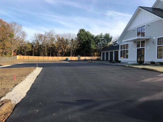 A large white house with a large driveway in front of it.