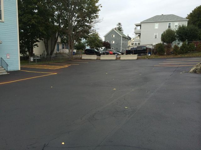 A parking lot with a blue building in the background.