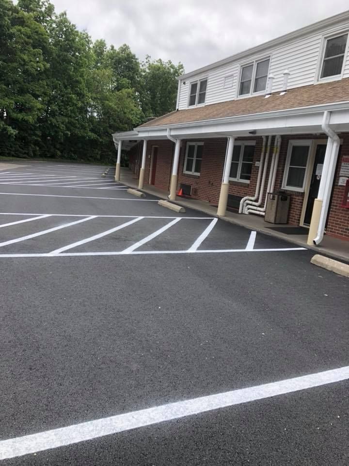 A parking lot in front of a building with white lines on it.