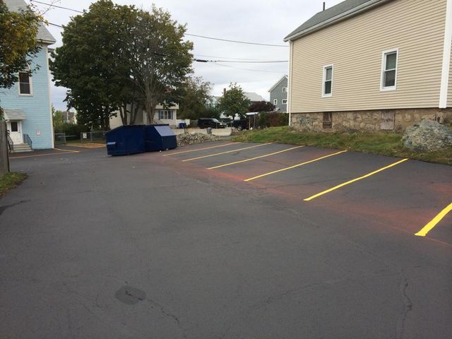 A parking lot with yellow lines in front of a house