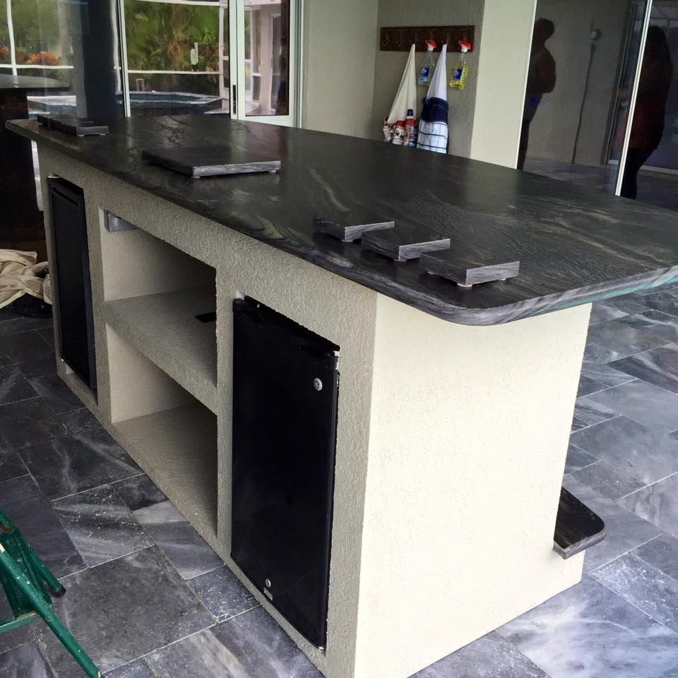 A kitchen island with a black granite counter top