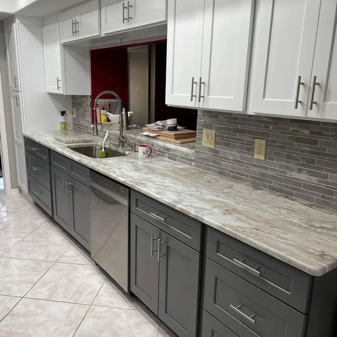 A kitchen with gray cabinets , white cabinets , a sink , and a dishwasher.