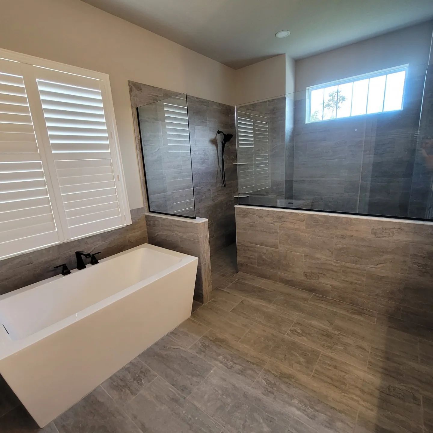 A bathroom with a bathtub and a walk in shower.