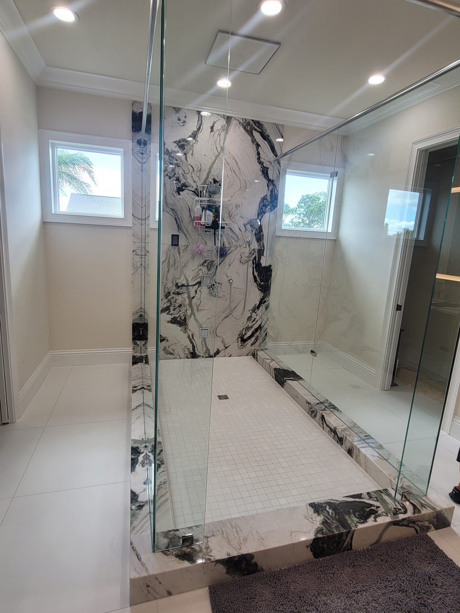 A bathroom with a walk in shower and a large mirror.