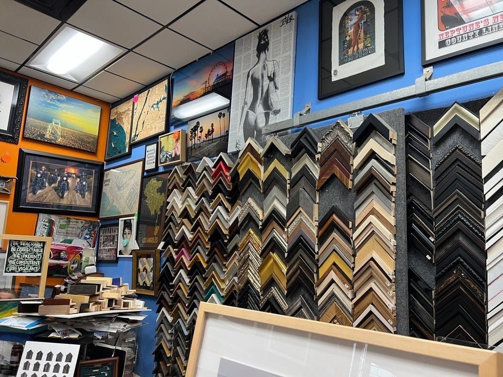 Interior of an art framing shop, with framed artwork and many frame samples on display.
