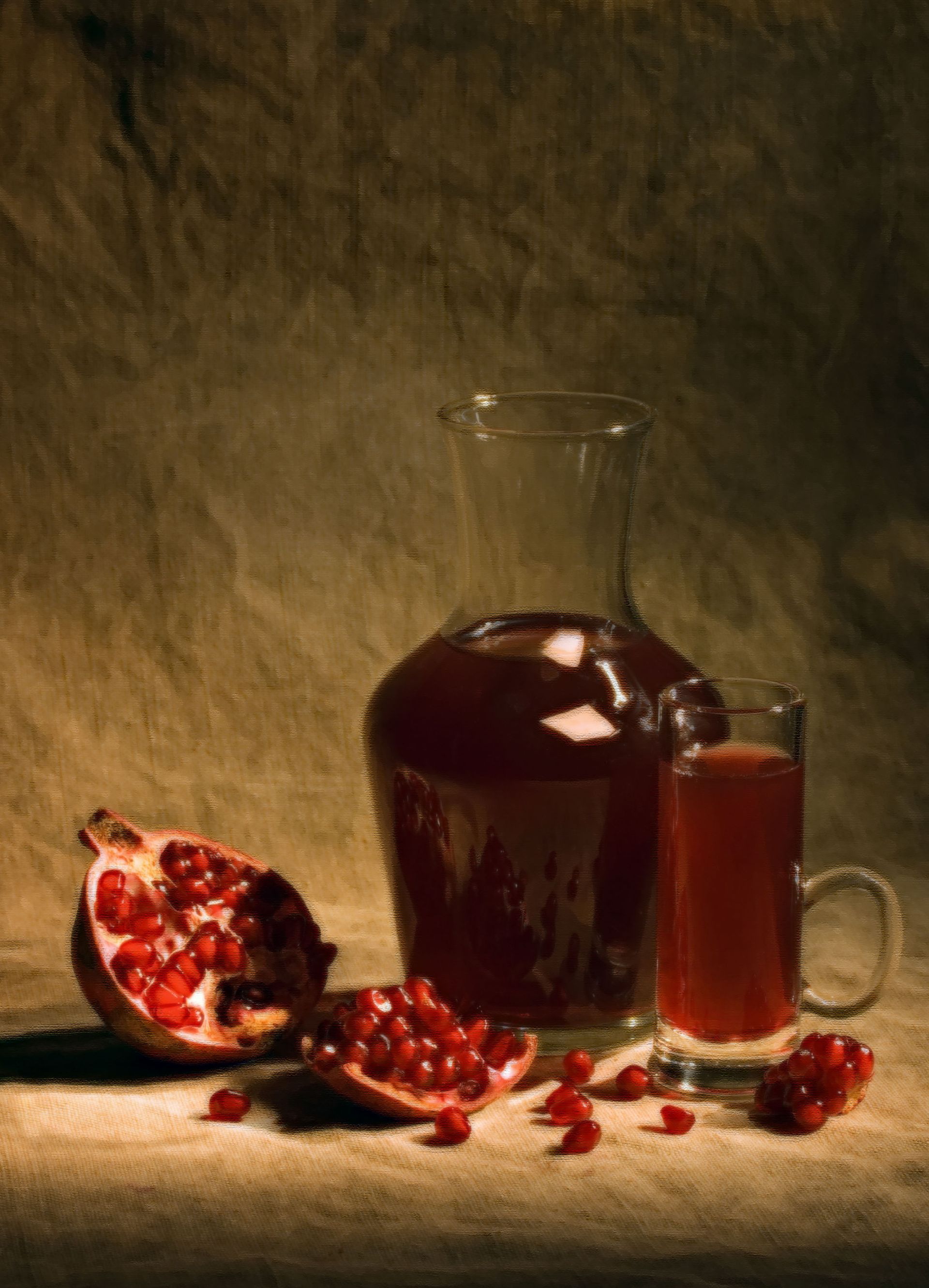 Pomegranate fruit, juice in a glass and pitcher on a textured surface, sepia tones.