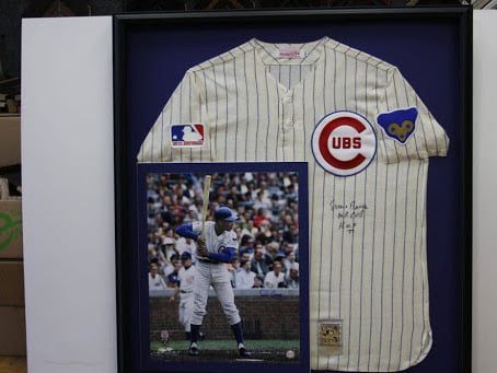 Framed Chicago Cubs baseball jersey and photo of player in action. Blue, white, and red colors are prominent.