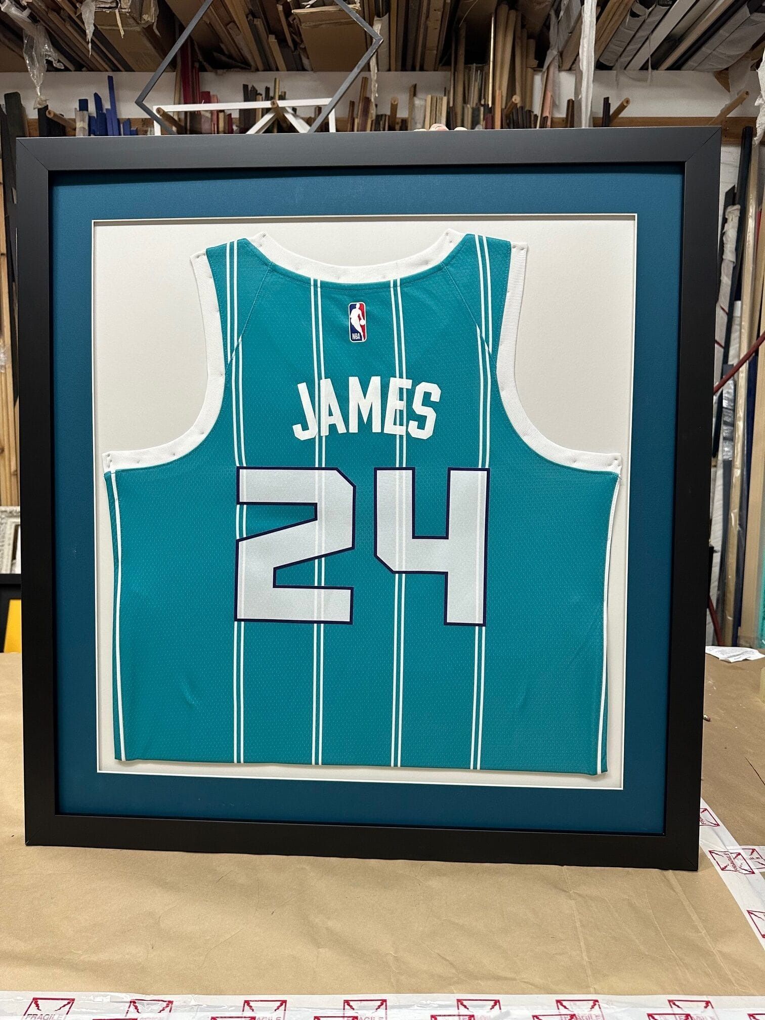Framed teal and white basketball jersey with 
