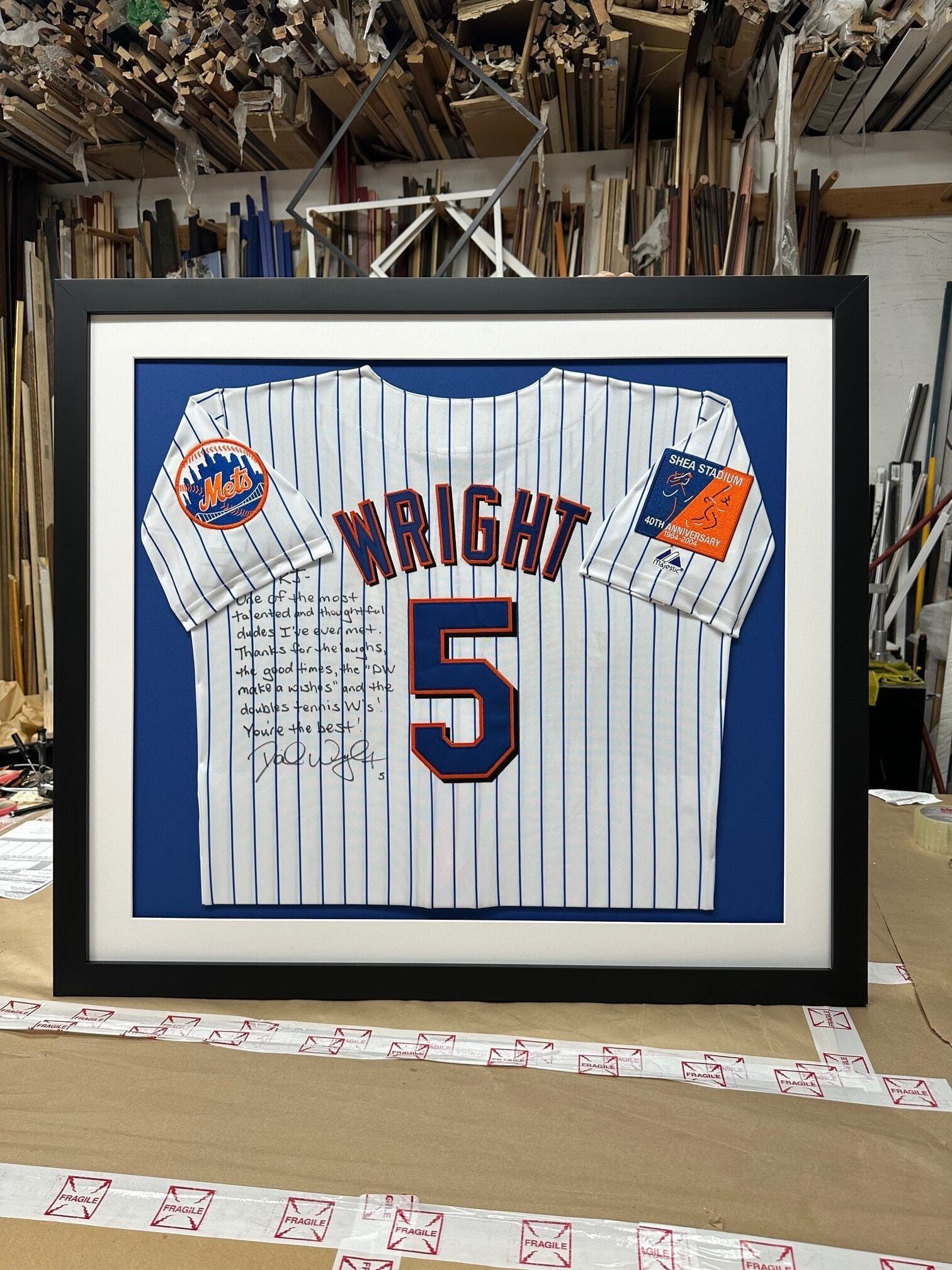 Framed New York Mets baseball jersey, white with blue and orange accents. 