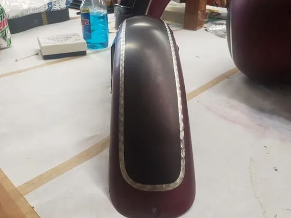 Close-up of a maroon chair with a black cushioned backrest on a table