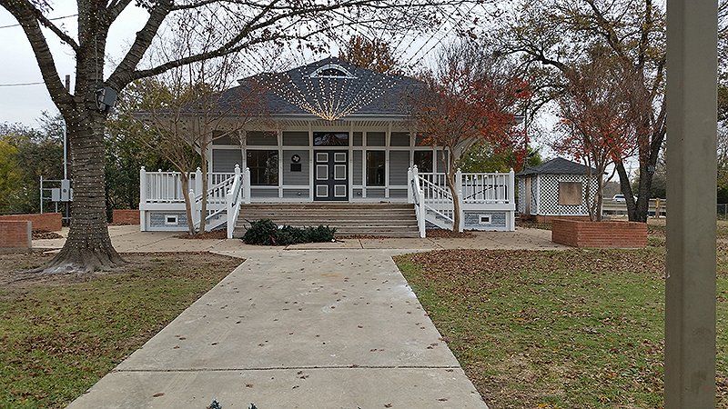 A newly painted large white house with a walkway leading to it