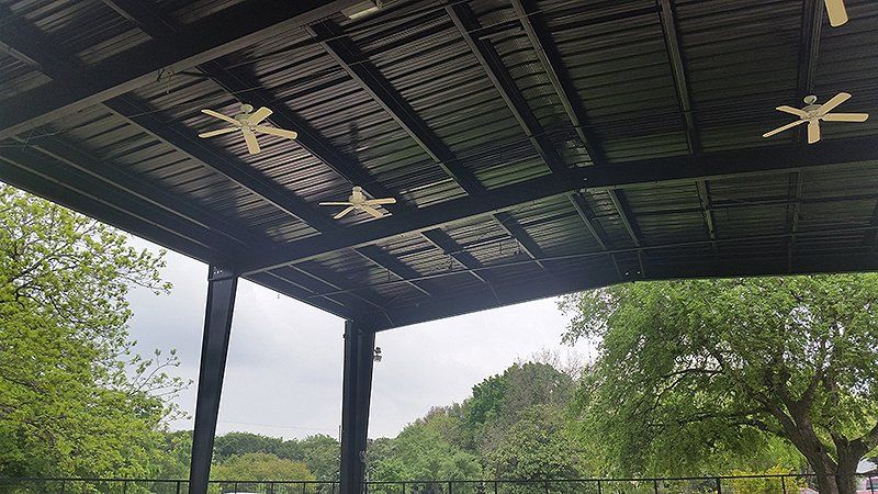 Ceiling fans hanging from the ceiling of a metal structure