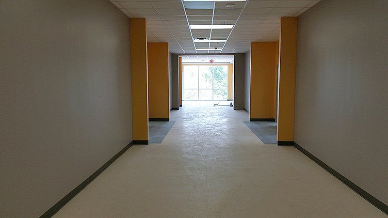 An empty hallway with yellow walls and a large window