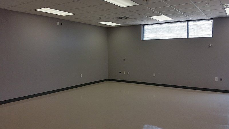 A large empty room with gray walls and a window
