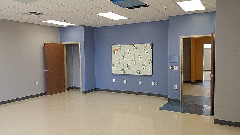 An empty room with blue walls and a white board on the wall