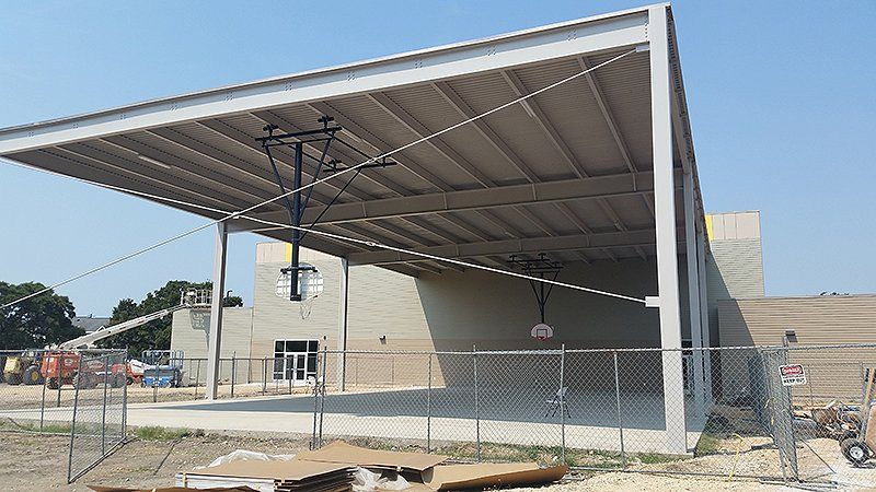 A large gym under construction with a fence around it
