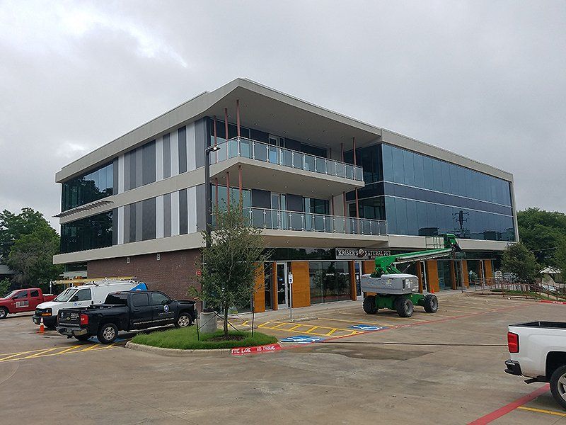A large building with a lot of windows and trucks parked in front of it