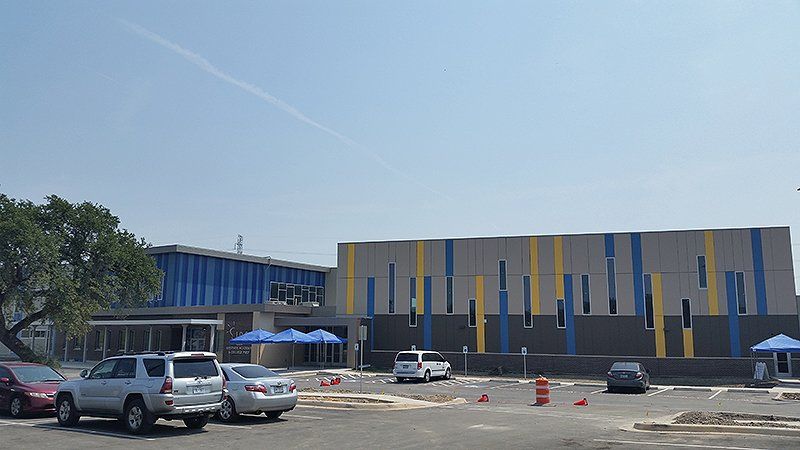 A parking lot with cars parked in front of a large building