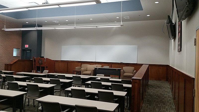 A large classroom with rows of tables and chairs