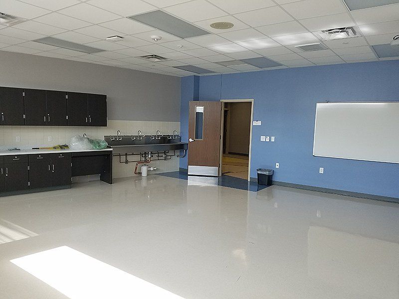 An empty room with blue walls, sink, and a white board