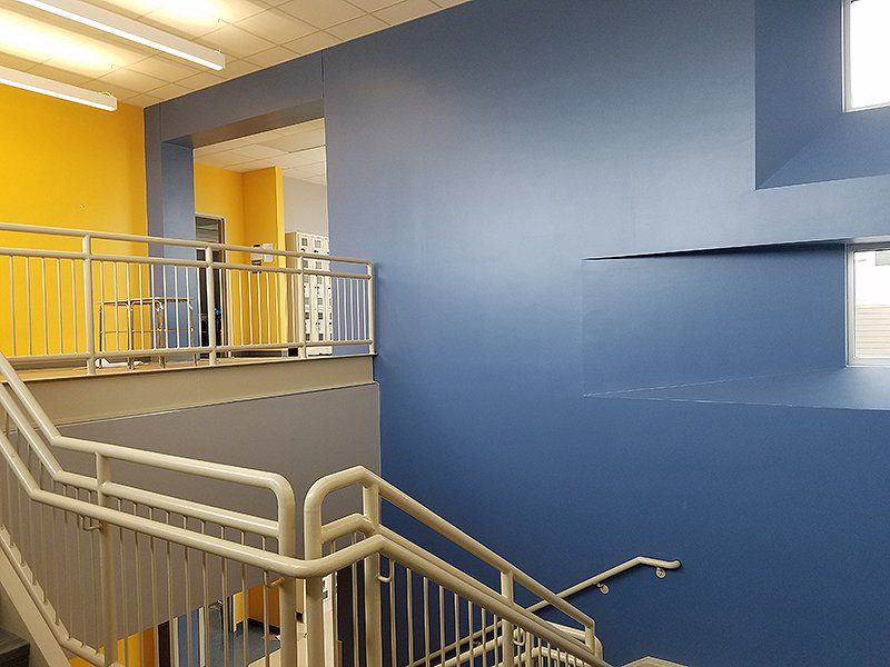 A staircase in a building with blue walls and yellow walls