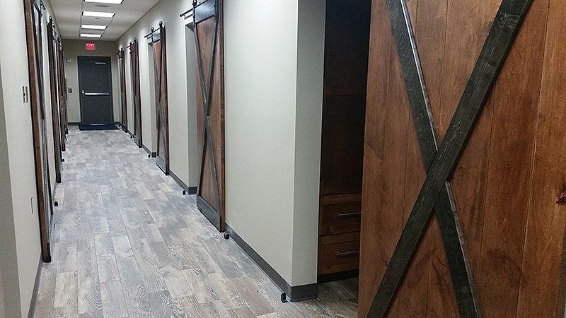 A long hallway with sliding barn doors in a building
