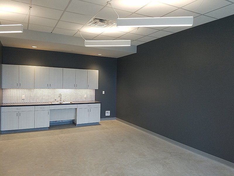 An empty room with gray walls and white cabinets