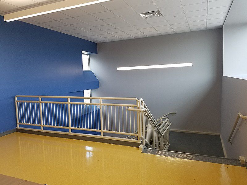 A staircase with a yellow floor and blue walls