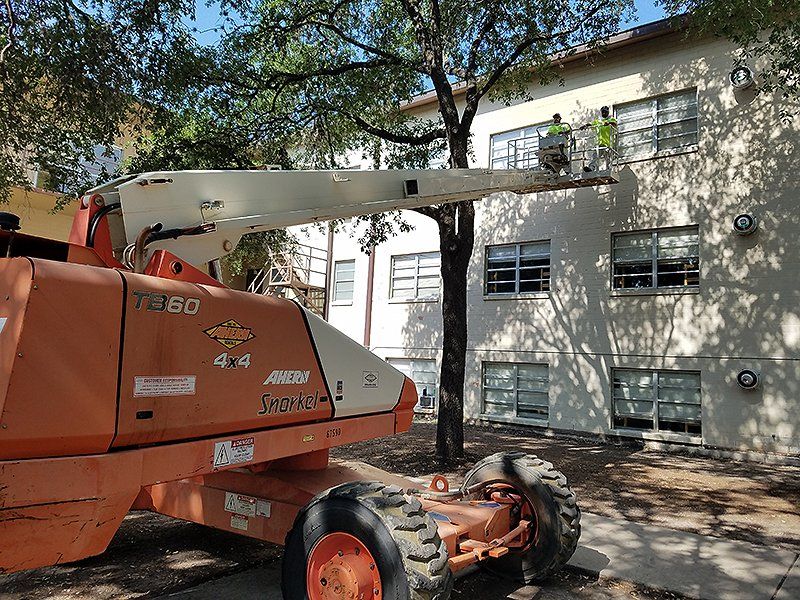 Men standing on a lift in front of a building