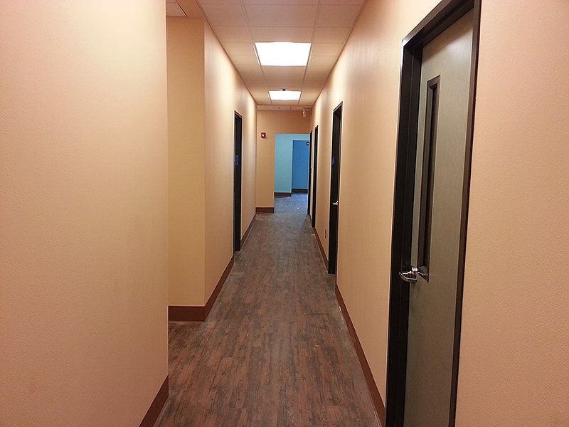 A long hallway with wooden floors and doors