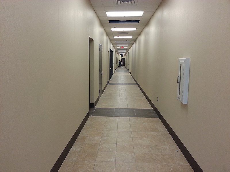 A long hallway with a fire extinguisher on the wall