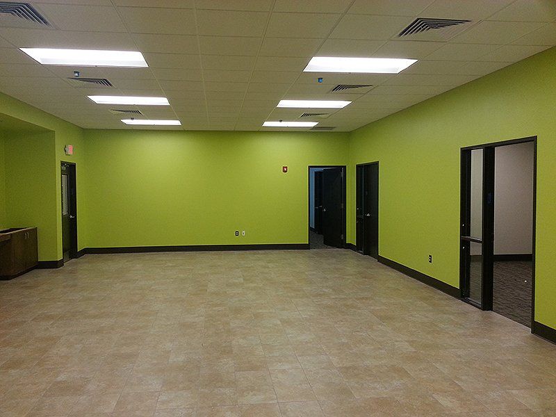 An empty room with green walls and a tiled floor