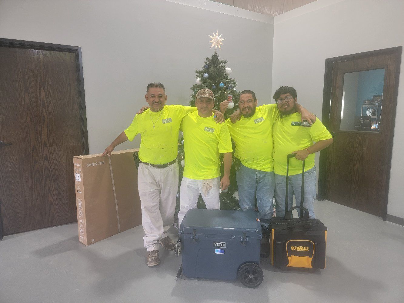A group of men are posing for a picture in front of a Christmas tree