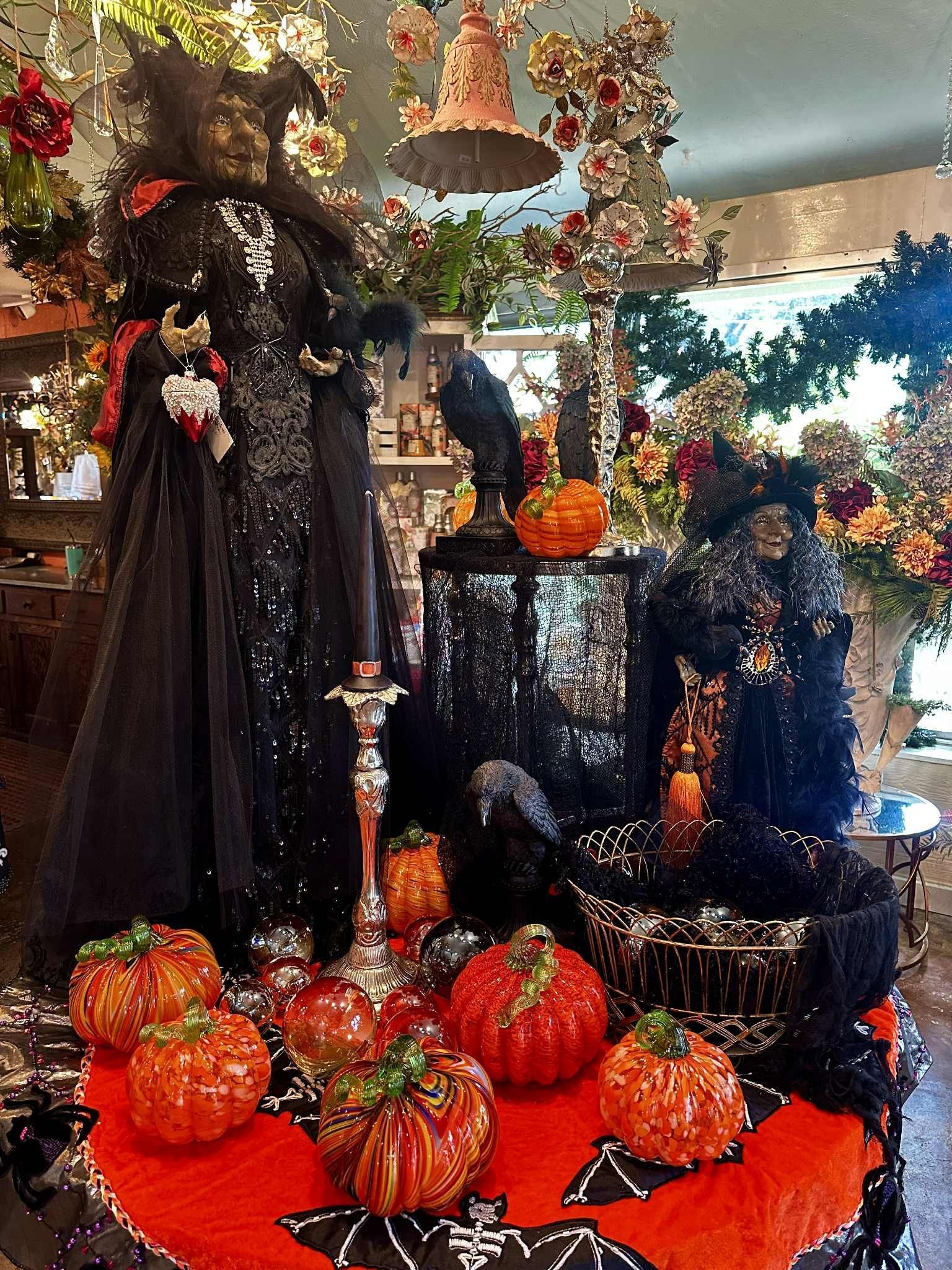 Halloween display with a witch, pumpkins, and black crow.