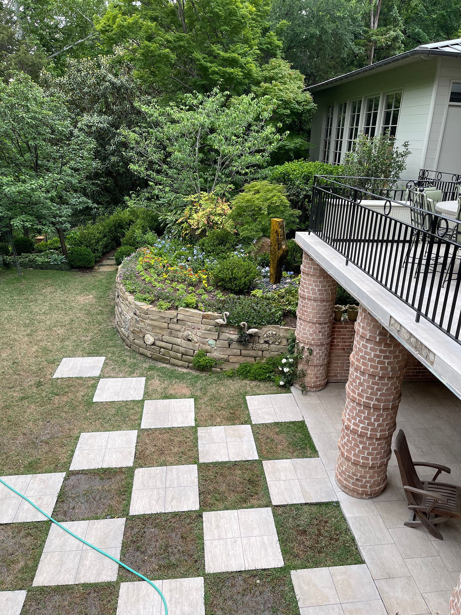 There is a checkered patio in the backyard of a house.