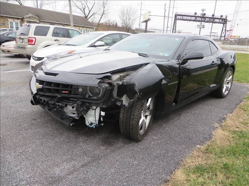A black car with a damaged front end is parked in a parking lot.