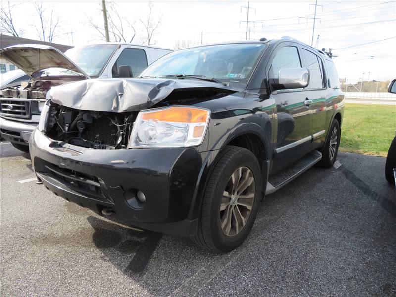 A black suv with a damaged front end is parked in a parking lot.