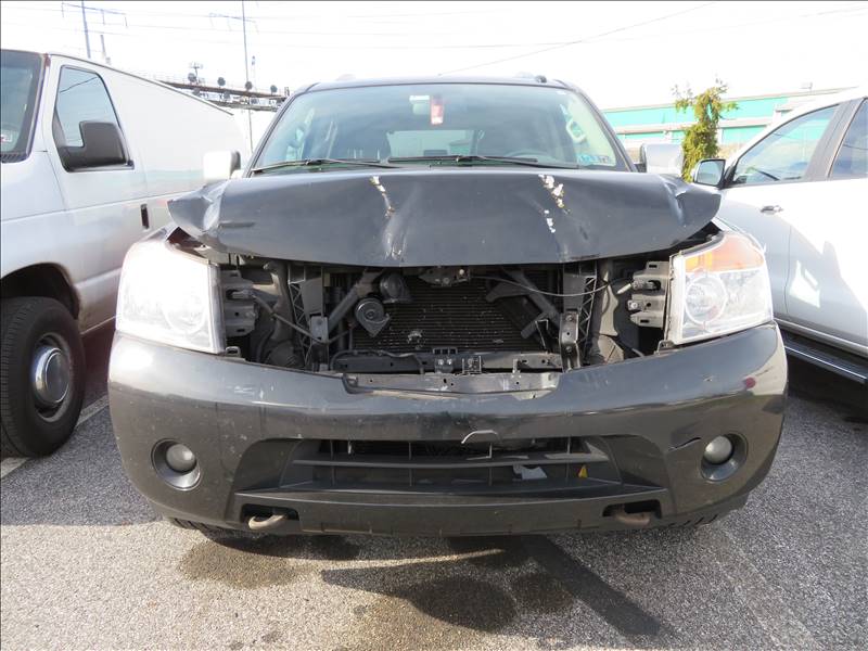 A black car with its hood open is parked in a parking lot.