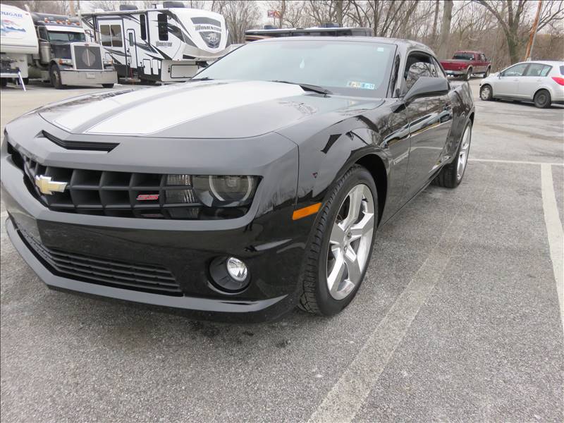 A black chevrolet camaro is parked in a parking lot