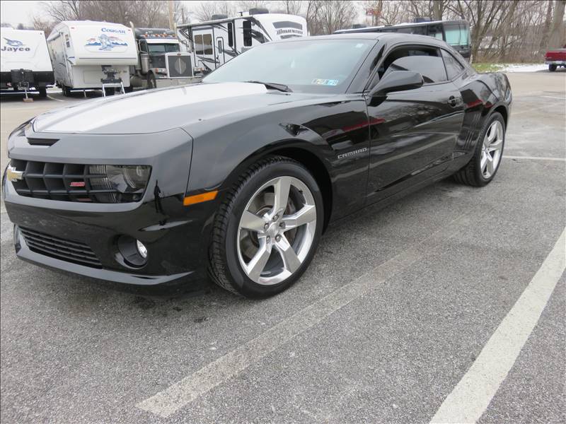 A black chevrolet camaro is parked in a parking lot