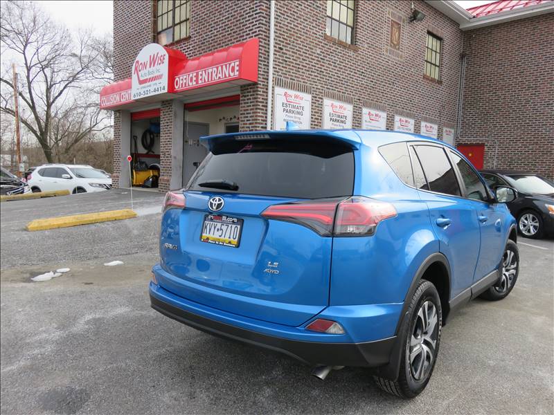 A blue toyota rav4 is parked in front of a car wash