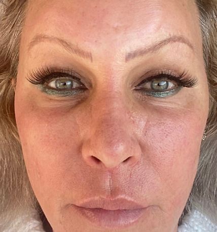 Close-up of a person’s face with heavy eye makeup and a neutral expression