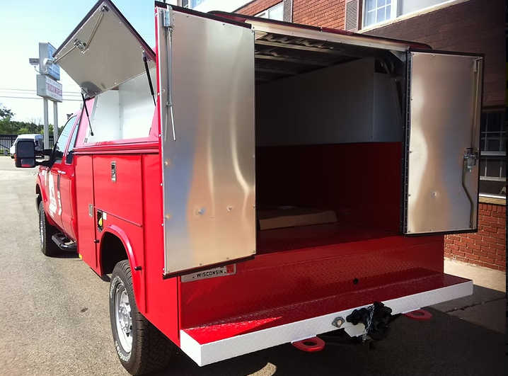 Red work truck with open doors revealing a storage area.