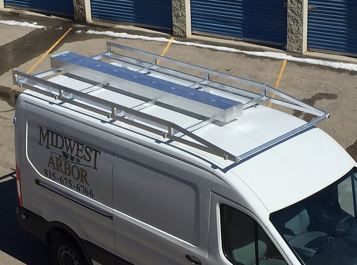 White van with a silver roof rack; the side reads 